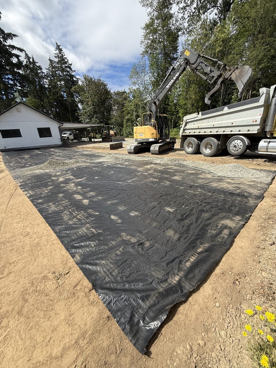 Excavator loading a dump truck during gravel placement